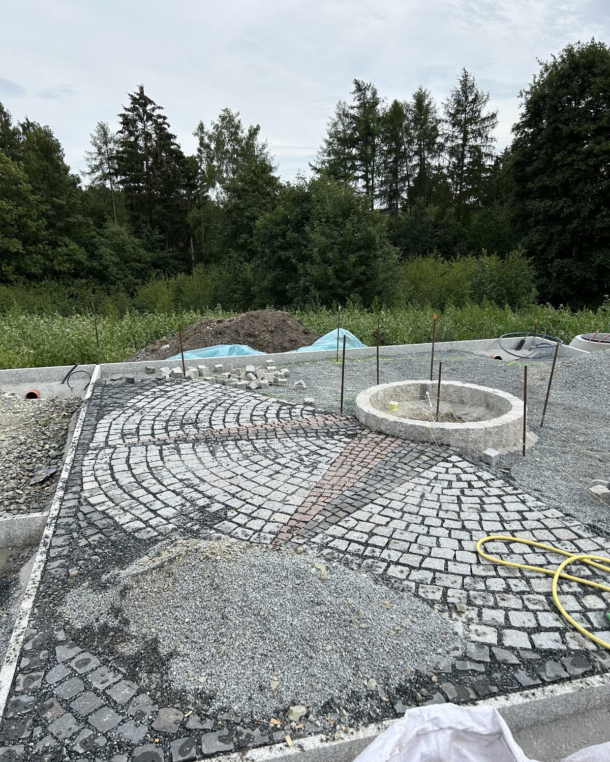 Rund verlegte Natursteinpflasterung mit Rosette während der Bauphase